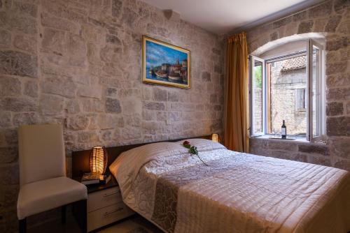 a bedroom with a bed and a chair and a window at Apartments Dora -Free parking in Trogir
