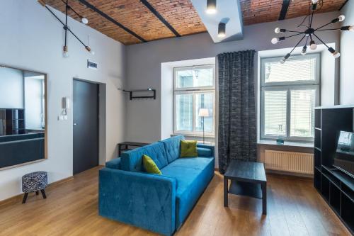 a living room with a blue couch and a tv at Apartamenty Centrum Częstochowa Stara Kamienica in Częstochowa