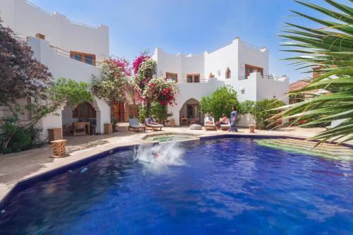 a swimming pool in front of a house at Red C Villas in Dahab