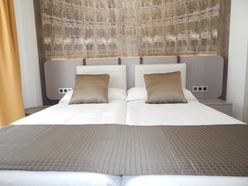 a bedroom with a bed with two pillows at Hostal Boutique Doña Carmen - Adults Recommended in Nerja