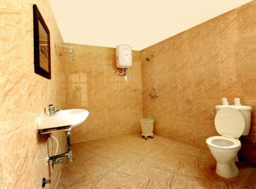 a bathroom with a toilet and a sink at Kunwar Residency in Rishīkesh
