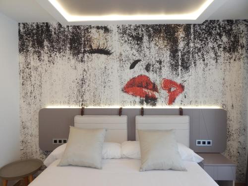 a bedroom with a bed and a painting on the wall at Hostal Boutique Doña Carmen - Adults Recommended in Nerja