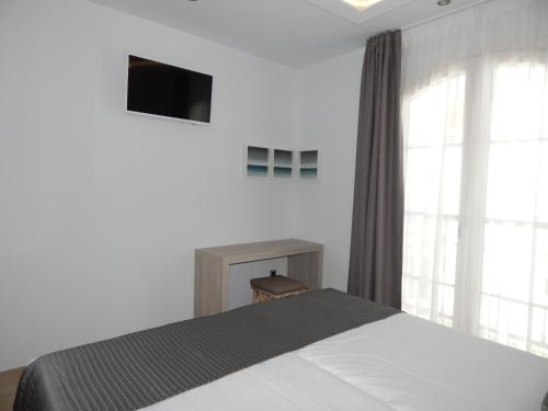 a bedroom with a bed and a tv on the wall at Hostal Boutique Doña Carmen - Adults Recommended in Nerja