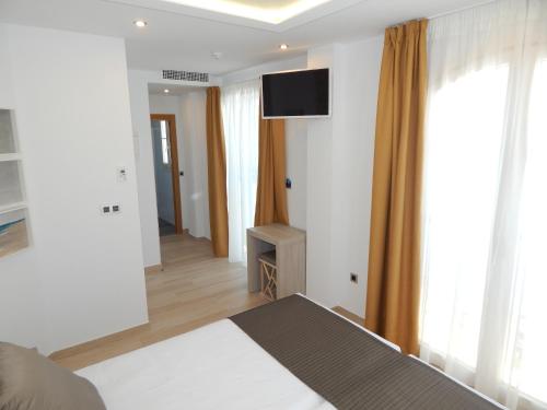 a bedroom with a bed and a television on the wall at Hostal Boutique Doña Carmen - Adults Recommended in Nerja