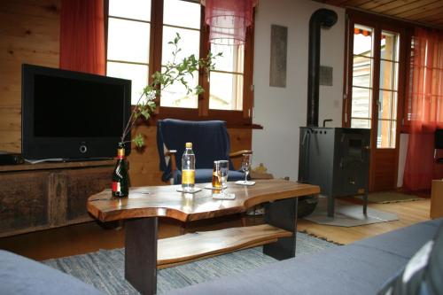 a living room with a wooden table and a television at Bergdohle in Adelboden