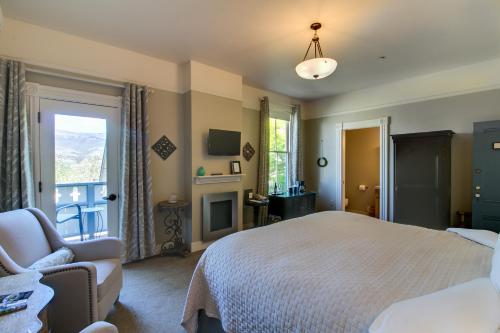 a bedroom with a bed and a chair and a window at Winchester Inn in Ashland