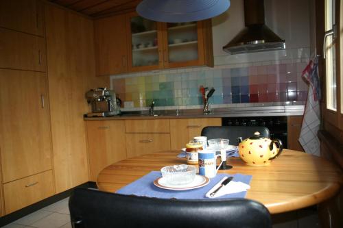 a kitchen with a wooden table with a blue table cloth at Bergdohle in Adelboden