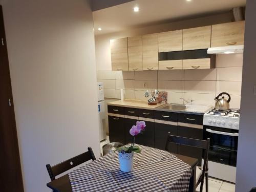 a kitchen with a table with a purple flower on it at Kwatera prywatna in Augustów