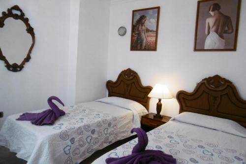 2 Betten in einem Zimmer mit lila Handtüchern darauf in der Unterkunft Carlos y Rosa in Puerto de la Cruz