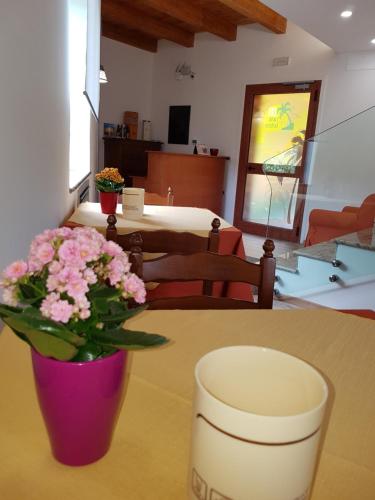 a table with a vase with pink flowers on it at San Pietro in Mileto