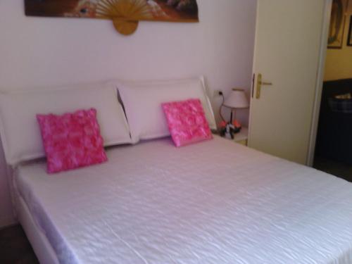 una camera da letto con un letto con cuscini rosa di Appartamento Libertà a Portovenere