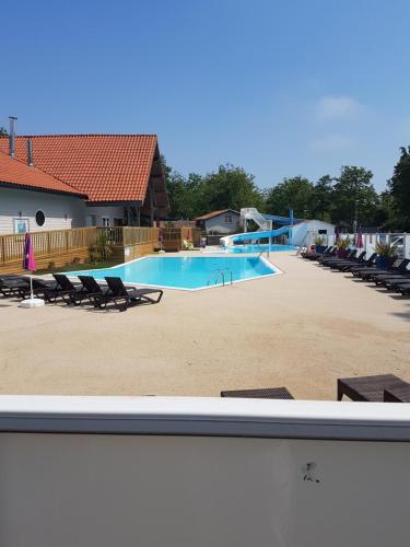 une grande piscine avec des chaises longues dans l'établissement Mobil Home Soulac, à Soulac-sur-Mer