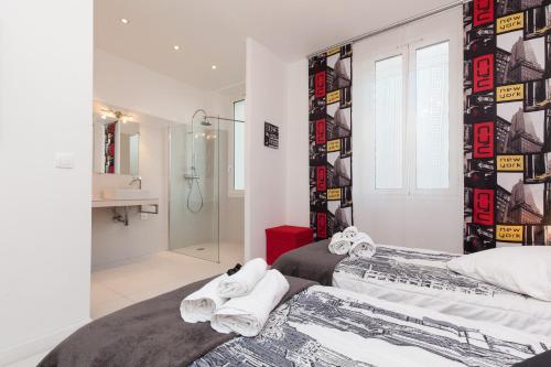 Cet appartement comprend une chambre avec deux lits et une salle de bains pourvue d'une douche. dans l'établissement Manhattan 2 pièces 3 étoiles lumineux plein centre à 5mn des plages et palais, à Cannes