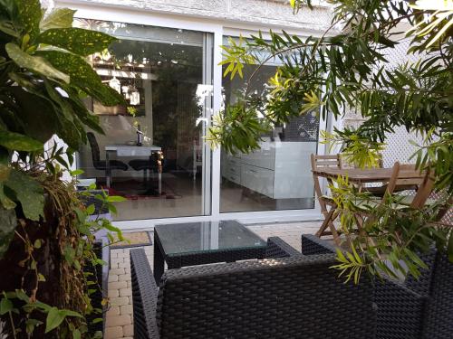 a patio with a glass table and a bench at The Sun House in Santa Iria da Azóia