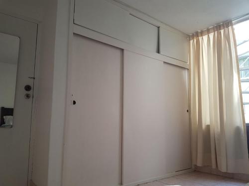 a white wall with a window and a curtain at Hospedaje de Lidia in Lima