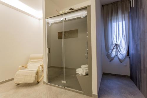 uma porta de duche em vidro num quarto com uma cama em Residence Hill em San Quirico dʼOrcia