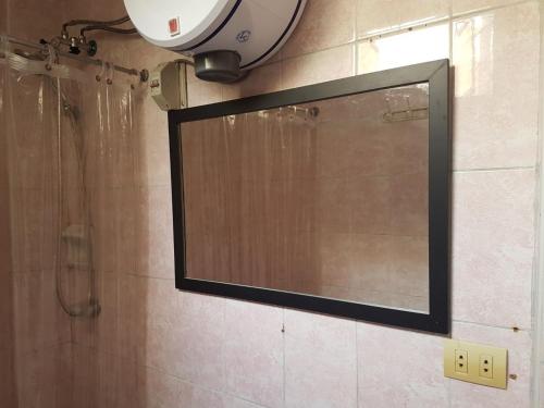 a mirror on the wall of a bathroom with a shower at Hospedaje de Lidia in Lima