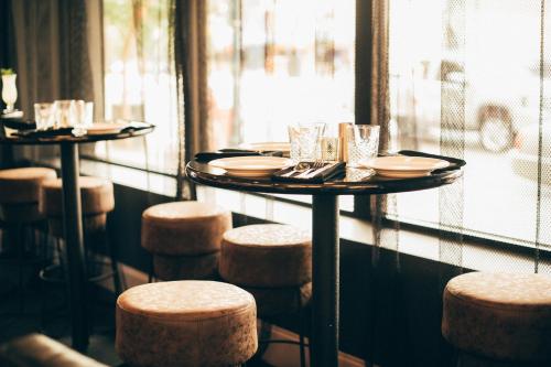 a table in a restaurant with stools and plates at Hampton Inn & Suites New Orleans Canal St. French Quarter in New Orleans