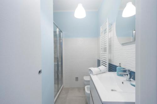 a white bathroom with a sink and a toilet at Un soffio dal cielo in Beverino