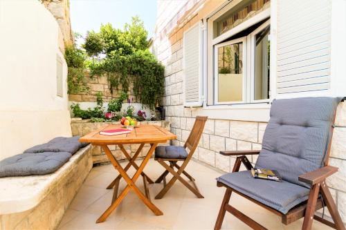 a patio with a wooden table and two chairs at Apartments Viva in Korčula
