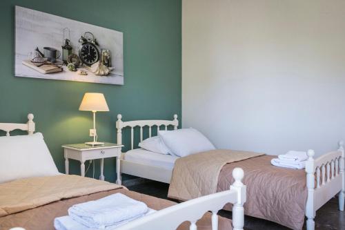 a bedroom with two beds and a table with a lamp at Dendrolivano in Minia