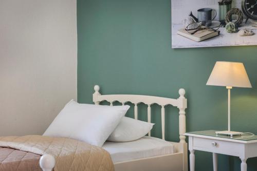 a bedroom with a bed and a table with a lamp at Dendrolivano in Minia