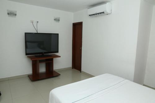 a room with a tv and a bed in it at Hotel Yivinaca in Barranquilla