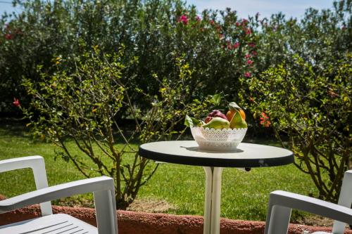 a bowl of fruit on a table with two chairs at Dendrolivano in Minia