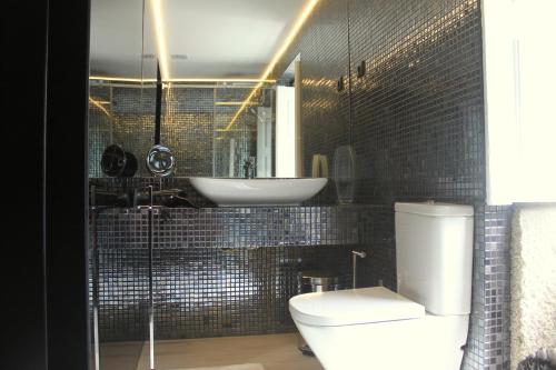 a bathroom with a white toilet and a sink at Casa do Largo do Cais in Vila Nova de Cerveira