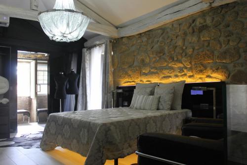 1 dormitorio con cama y pared de piedra en Casa do Largo do Cais, en Vila Nova de Cerveira