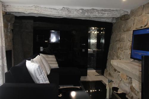 a living room with a couch and a television at Casa do Largo do Cais in Vila Nova de Cerveira