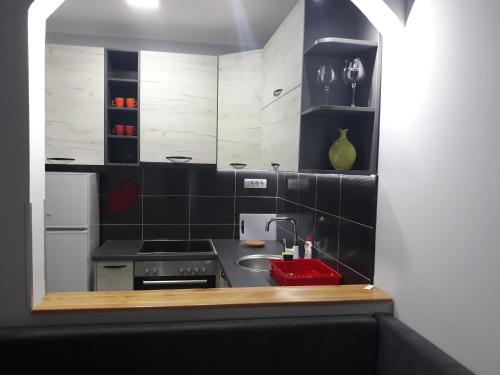 a kitchen with black and white tiles and a sink at Apartment Azzuro 2 in Novi Sad