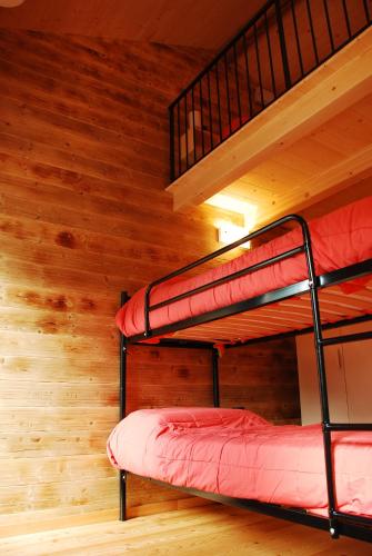 two bunk beds in a room with wooden floors at La casa del borgo in Dervio
