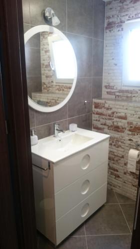 łazienka z białą umywalką i lustrem w obiekcie Apartment Joanna Grau de Gandia w mieście Los Mártires