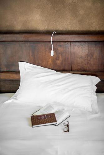 a book sitting on a bed with a book gmaxwell gmaxwell gmaxwell at Bellavista Boutique Hotel in Brunate