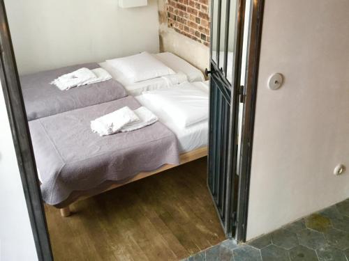 two beds in a small room with a mirror at Cluny La Sorbonne Paris in Paris