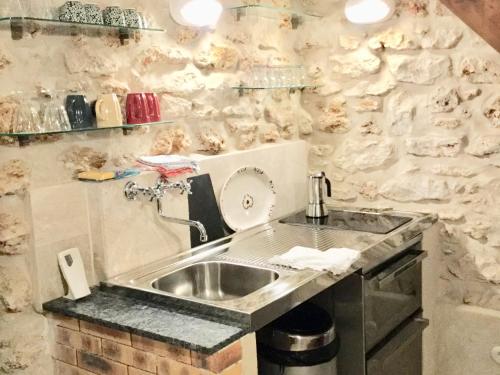 a kitchen with a sink and a stone wall at Cluny La Sorbonne Paris in Paris