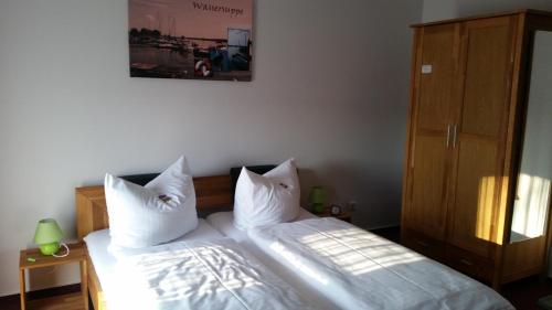 a bedroom with two beds with white sheets and pillows at Pension Am Dorfanger in Hohennauen