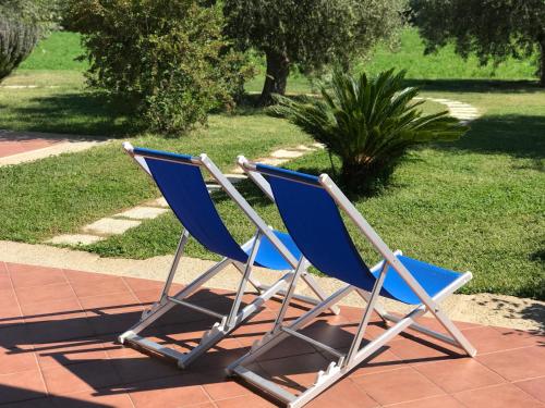 two blue chairs are sitting on a patio at Su Cannonariu in Orosei
