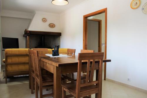 ein Esszimmer mit einem Holztisch und Stühlen in der Unterkunft Casa da Maria Moca in Fátima