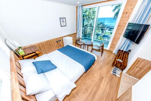 a bedroom with a bed and a large window at Jeju Aurum in Seogwipo