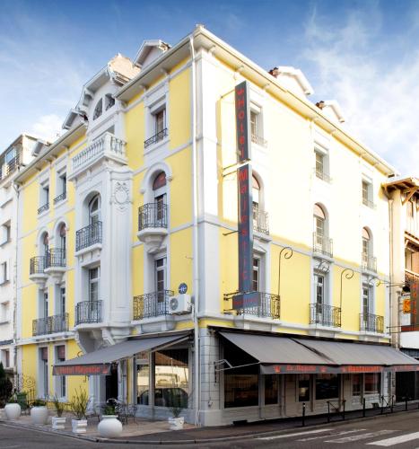 a yellow and white building on a street at Hôtel Majestic in Lourdes