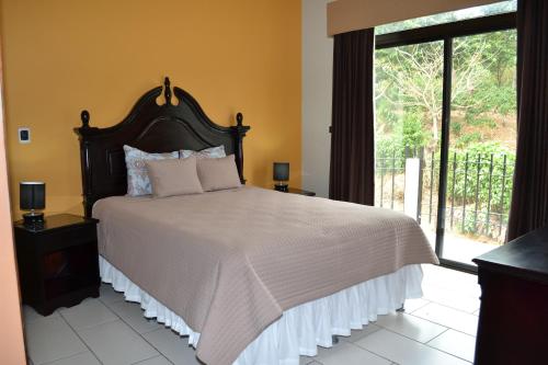 Vista Los Volcanes Hotel y Restaurante في Juayúa: غرفة نوم بسرير كبير ونافذة كبيرة