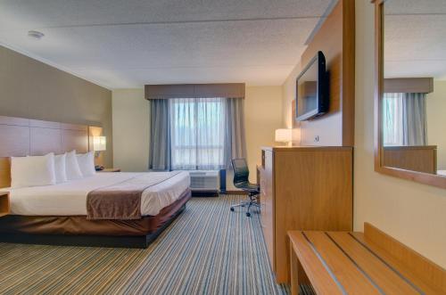 a hotel room with a bed and a flat screen tv at Best Western Royal Plaza Hotel and Trade Center in Marlborough
