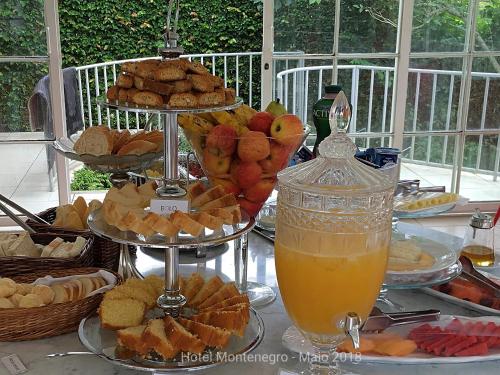 a table topped with plates of food and a drink at Hotel Montenegro Guaramiranga in Guaramiranga