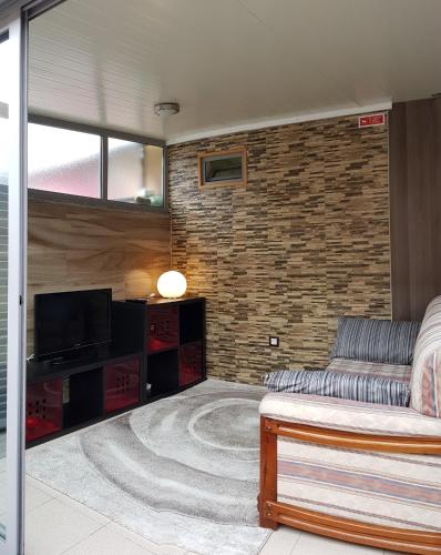 a living room with a couch and a television at O Ninho in Vila Nova de Gaia