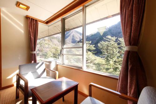 a room with a table and a large window at Shimobe Hotel in Minobu