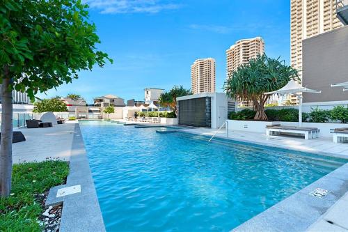 a swimming pool with blue water and buildings at H Star Residences-- Paradise Stayz in Gold Coast