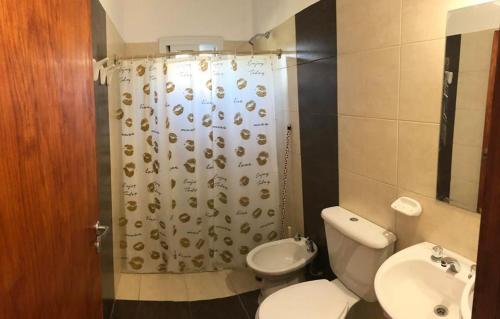 a bathroom with a toilet and a shower curtain at Cabañas 6 Olivos in San Rafael