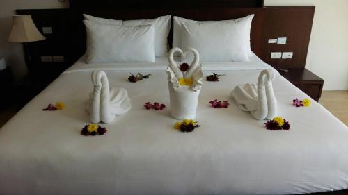 a bed with two bunny towels and flowers on it at Aonang Regent Hotel in Ao Nang Beach
